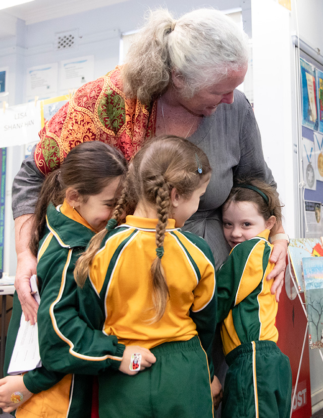 St Patrick's Catholic Primary School Parramatta students hugging dedicated teacher